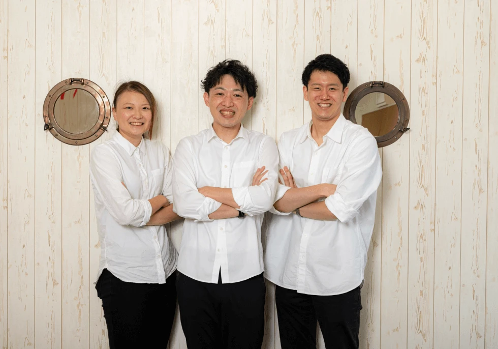 信頼ある専属トレーナーが3名笑顔で立っている